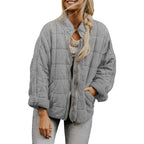  Oversized quilted zip jacket in light grey with collarless design and relaxed fit, front view.