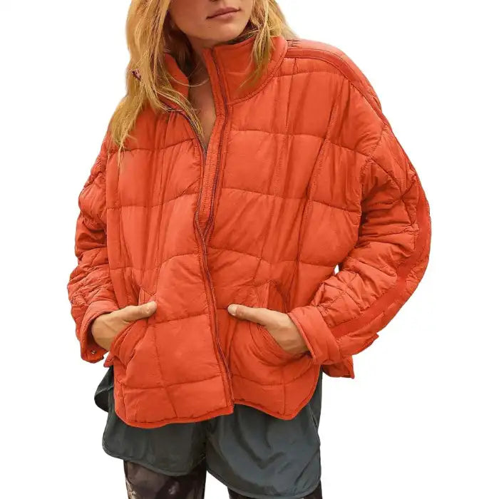  Oversized quilted zip jacket in rust orange with detailed quilting and zipper detail, closeup view.