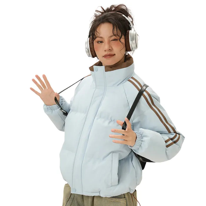 Blue Padded Puffer Jacket with brown accents worn playfully with headphones and loose-fit pants.