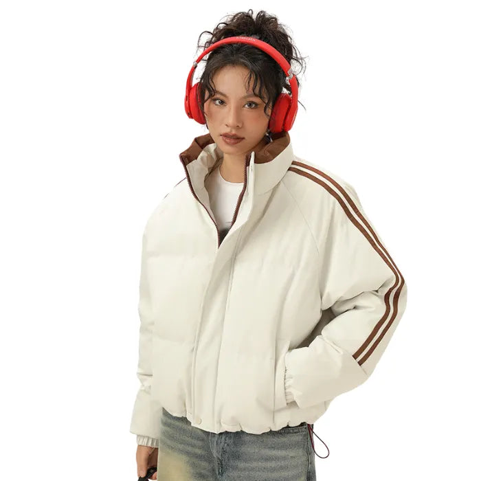 White Padded Puffer Jacket with brown stripe accents styled with headphones and light-wash jeans.