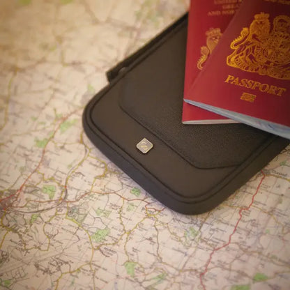 RFID travel wallet placed on detailed paper map, showcasing essential international travel security accessories