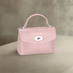 Pastel pink crocodile-textured leather handbag with silver detailing for elegant women's fashion.