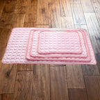 pet cooling pad collection showing stacked pink cooling mats in three different sizes with quilted bubble-pattern design