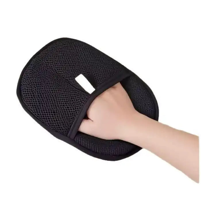 Pet hair remover glove held in hand featuring white tag on breathable black mesh surface