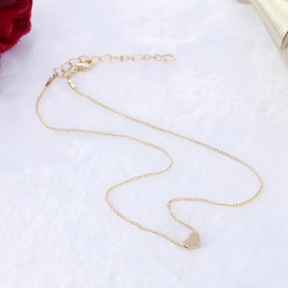 Gold-plated heart pendant necklace with delicate chain photographed on white background