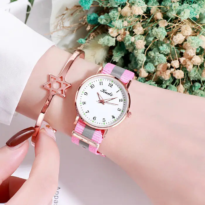 A women's watch with a pink and gray strap, white dial, and rose gold accents, paired with a rose gold bracelet featuring a star design.