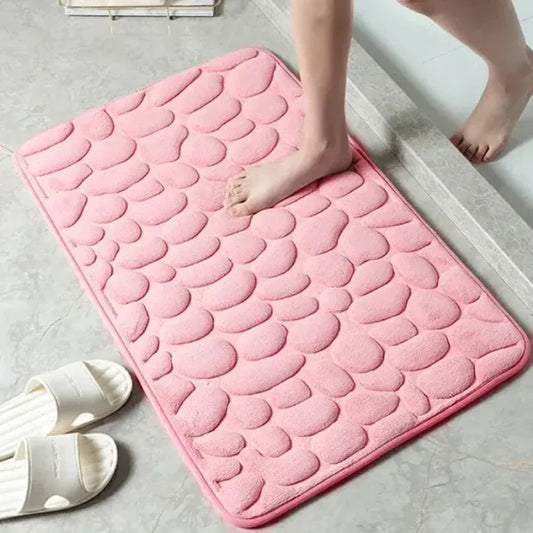 Pink scalloped bathroom mat with human feet, ideal for home comfort.