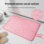 Pink coral velvet bath mat with pebble-like texture, enhances water absorption.