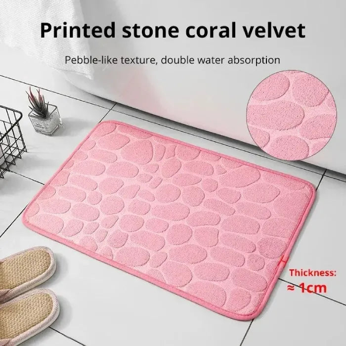 Pink coral velvet bath mat with pebble-like texture, enhances water absorption.