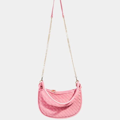 Pink woven leather crossbody bag with gold chain strap and curved shape