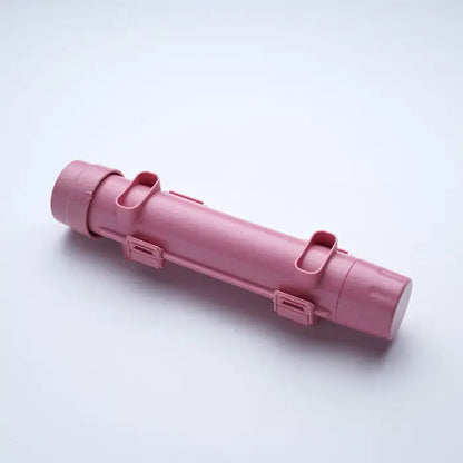 A pink DIY sushi roller mold placed on a plain white surface.