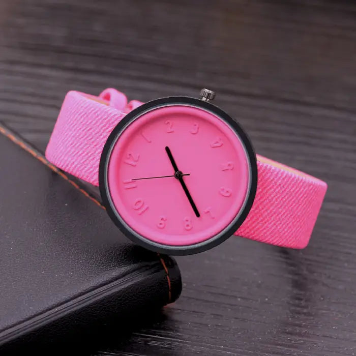 Bright pink wristwatch with bold minimalist dial and textured strap for stylish fashion accessories.