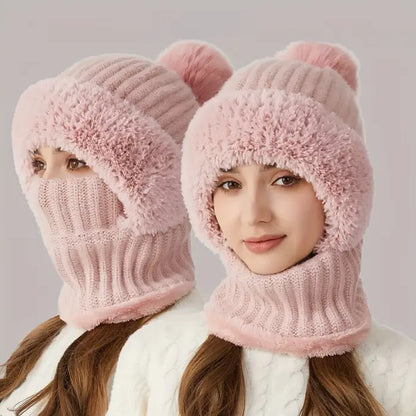 Person smiling while wearing a light pink fuzzy knit winter hat with an attached face covering 