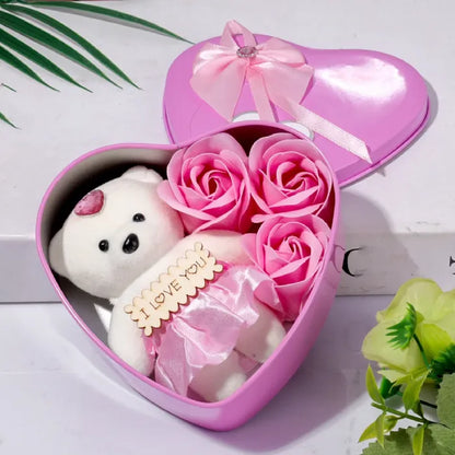 Pink heart box with teddy bear and roses arranged with decorative floral elements