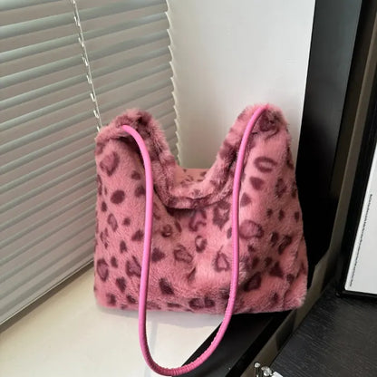 Pink leopard print faux fur handbag with a matching pink strap showcased against a modern setting.