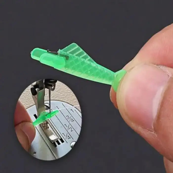 Close-up of green plastic needle threader being positioned into sewing machine needle eye for threading