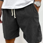 Size Men's Corduroy Shorts in black with drawstring waist and side pockets, worn with white shirt.