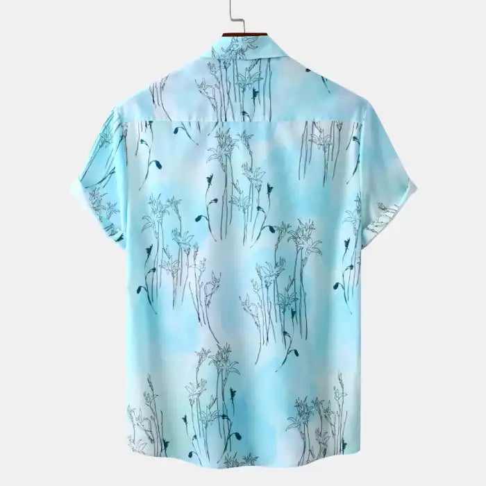 Plus size tropical shirt for men in light blue with floral patterns and short sleeves back view.