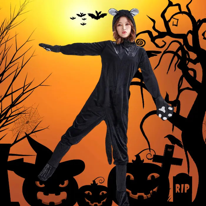 Plush black cat costume with spooky tree silhouettes and bats at Halloween sunset.