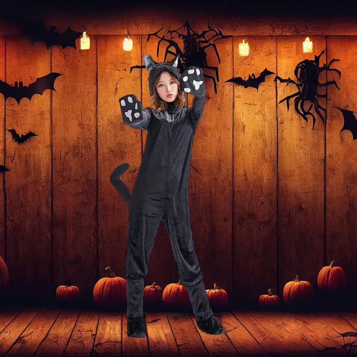Plush black cat costume in pumpkin-decorated wooden room with bats and Halloween lights.