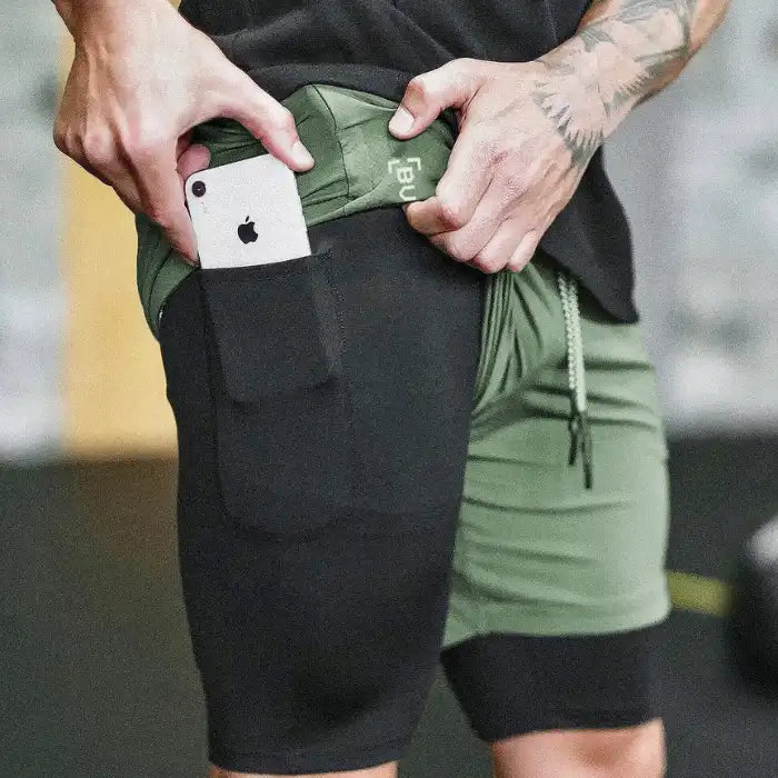 Green and black pocket compression shorts with phone storage pocket, suitable for gym and training.