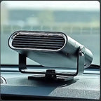 Sleek silver portable heater with oval grille mounted on car dashboard, adjustable stand, against blurred car interior background