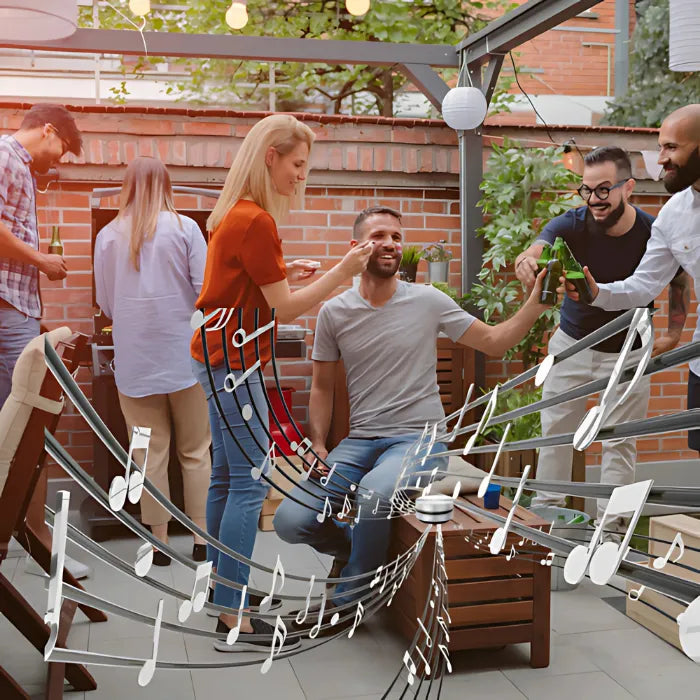 Portable speaker boosting sound at an outdoor party with friends enjoying drinks and music