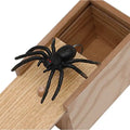 Close-up view of prank box with spider toy emerging from realistic wooden sliding lid.