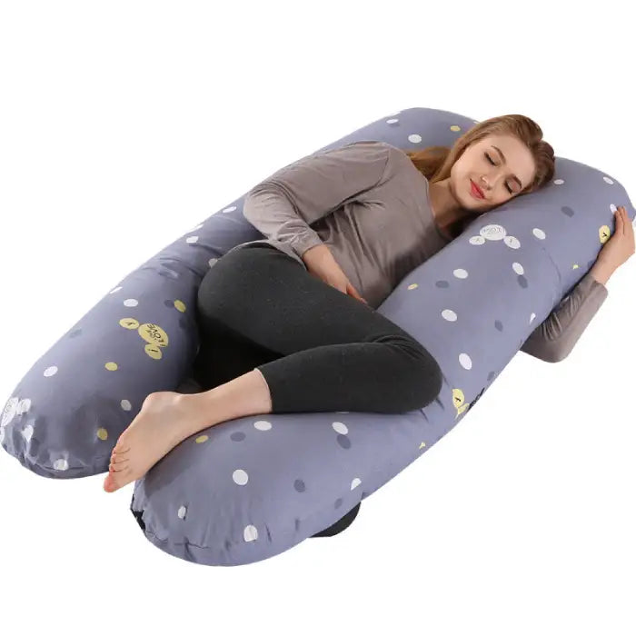 Blue pregnancy pillow with polka dot design and supportive shape for pregnancy comfort.