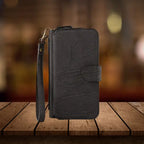 Premium iPhone wallet in black leather featuring elegant stitching pattern, secure snap closure and convenient wristlet strap attachment