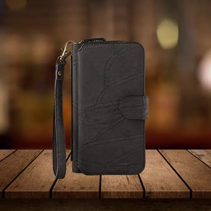 Premium iPhone wallet in black leather featuring elegant stitching pattern, secure snap closure and convenient wristlet strap attachment