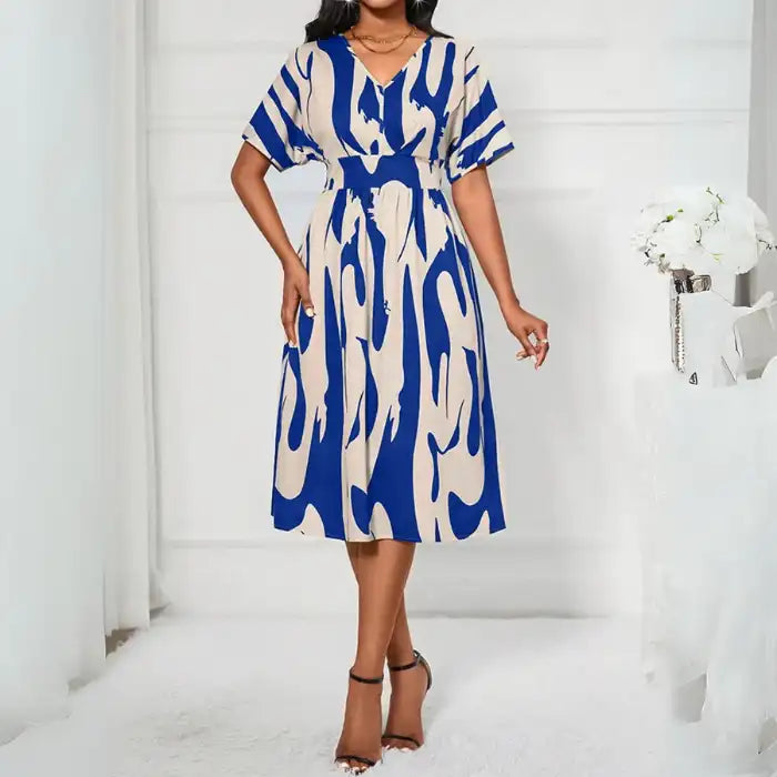 Printed v-neck short sleeve dress in abstract blue beige print styled for casual or semi-formal occasions.
