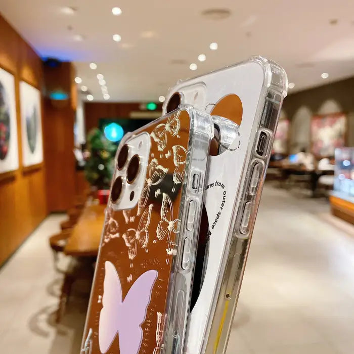 Protective iPhone 15 case with clean white background featuring "outer space" text and reflective circular mirror element