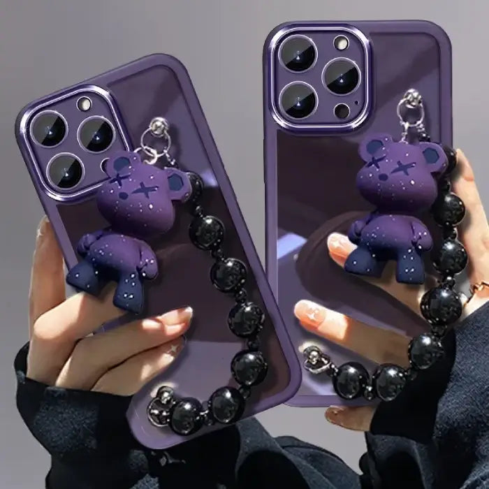 Purple Kuwaii Phone Case with cute bear charm and black beaded strap held in hand.