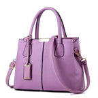 Fashionable purple leather tote bag with gold accents and detachable strap for stylish women.