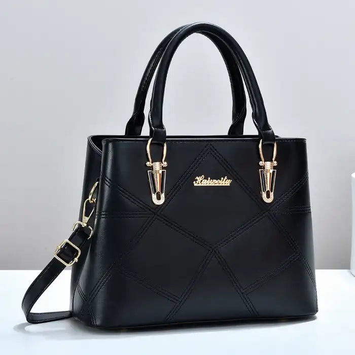Quilted faux leather satchel handbag in black with diamond stitching, dual handles, gold hardware, front view.