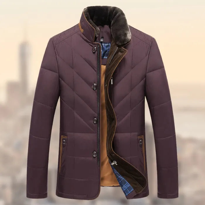 Quilted insulated jacket in maroon with fur collar and warm lining shown against a soft city backdrop.
