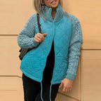 Quilted jacket in teal with diamond quilted body and textured knit sleeves, zip front design offering lightweight warmth and style