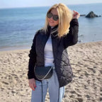 Quilted jacket in black with lightweight quilted body and knit sleeves, styled for breezy coastal days and travel comfort