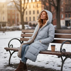 quilted puffer coat in light gray worn outdoors in winter, long women’s insulated coat designed for warmth
