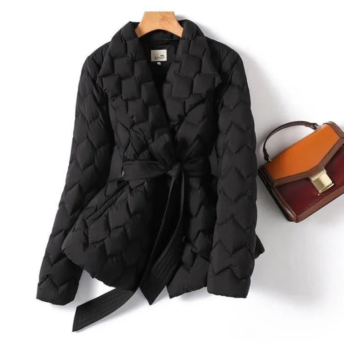 Quilted puffer jacket black belted design with quilt texture styled beside handbag, offering warm chic winter coat appeal