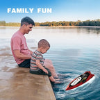 RC speed boat floating near father and son enjoying lakeside family fun moment together.