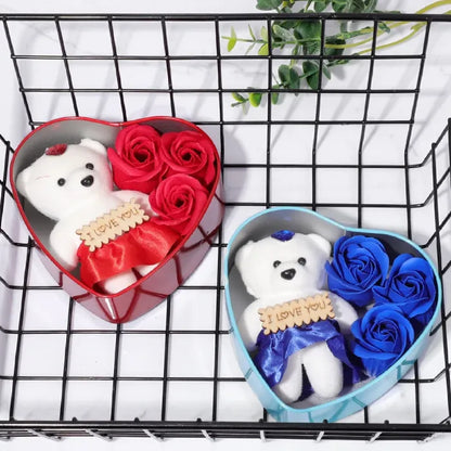 Red and blue heart-shaped gift boxes displayed on wire rack, featuring teddy bears and roses