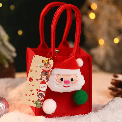 Red Christmas gift bag with a Santa ornament, pom-poms, and a festive holiday tag.