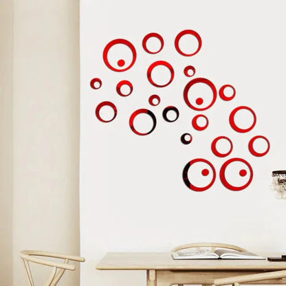 Round red mirrors of various sizes scattered on a white wall, enhancing decor near a table with books