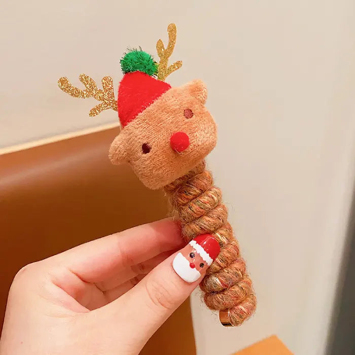 Close-up of a red and green Christmas tree-themed hair rope with colorful pom-poms and star details.