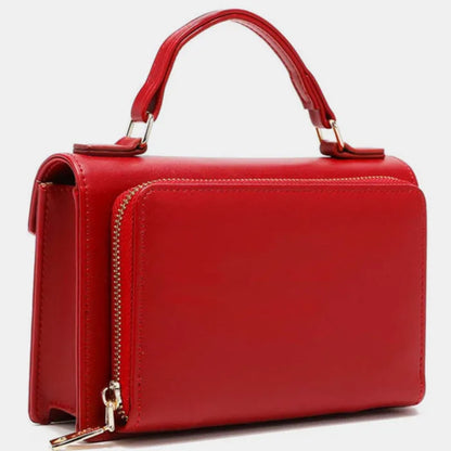 Side view of red leather handbag showing gold zipper detail, handle attachment, and smooth leather texture