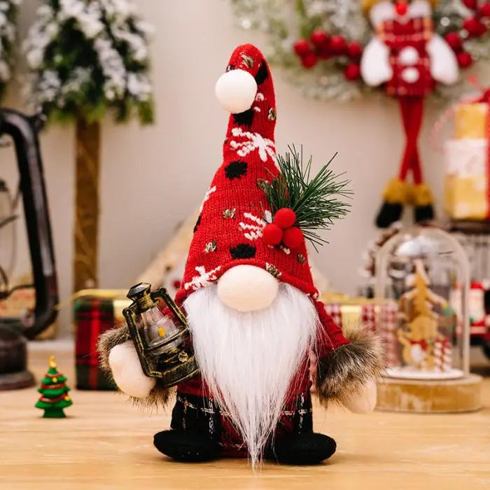 Close-up of a Christmas gnome with a red patterned hat, white beard, and miniature lantern, surrounded by holiday decorations