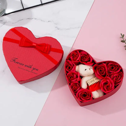 Open red heart-shaped gift box with teddy bear and red artificial roses, ideal for romantic gifts.