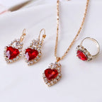 Stunning red gemstone heart jewelry set featuring necklace, earrings, and ring with crystal accents.